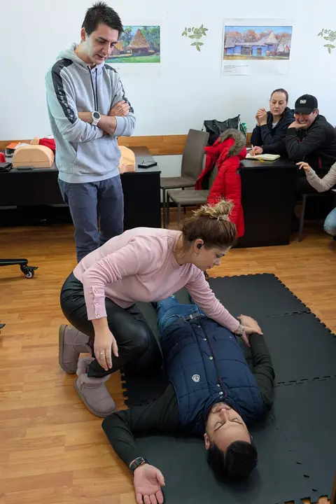 Așezarea în poziția laterală de siguranță, cu formatorul alături